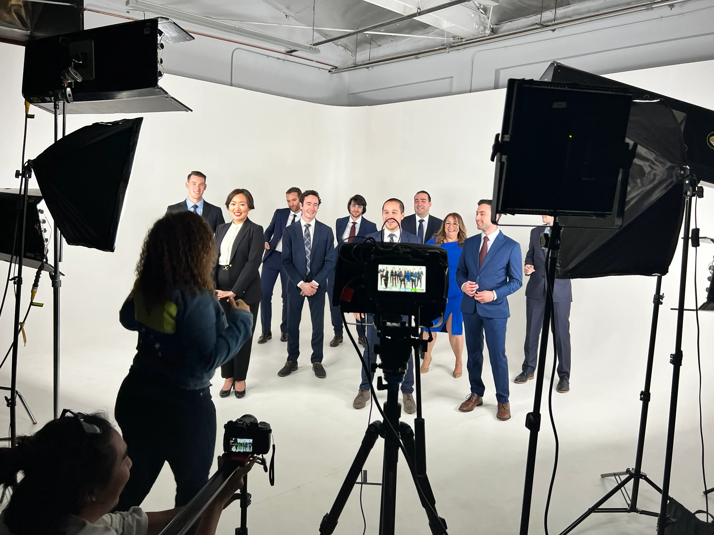 Grande's production team filming a group in a studio with cameras and lighting equipment